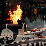 F1 driver's car bursts into FLAMES in the pit lane in Singapore while he's sitting inside - before quick-thinking mechanics from rival team Aston Martin step in to extinguish the fire